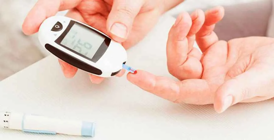 persona con un glucometro haciendose una medicion de los niveles de azucar en la sangre