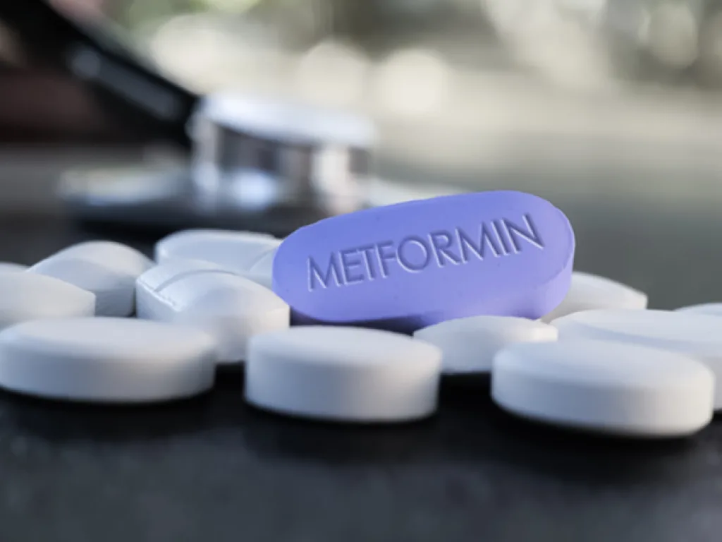 pastillas de metformina sobre una superficie plana, posiblemente una mesa.